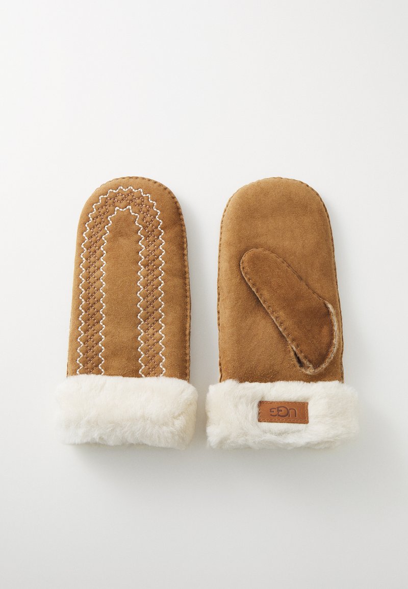 Brune semskede votter med hvite pelsmansjetter, med dekorativ søm og åpning for tommel på siden. UGG-logo på en mansjett.