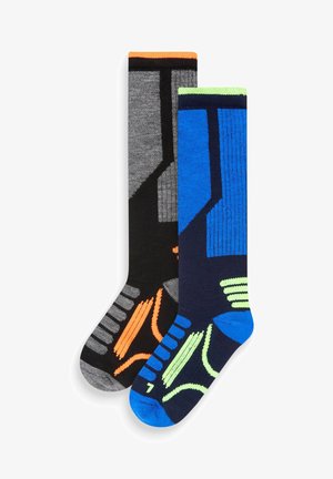 Due paia di calzini alti fino al ginocchio: uno in grigio scuro con accenti arancioni, l'altro in blu con motivi verde neon e nero. Texture lavorata a maglia.