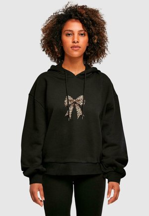 Black hooded sweatshirt made of soft material, featuring a leopard print bow graphic at the center. Loose fit with ribbed cuffs and hem.