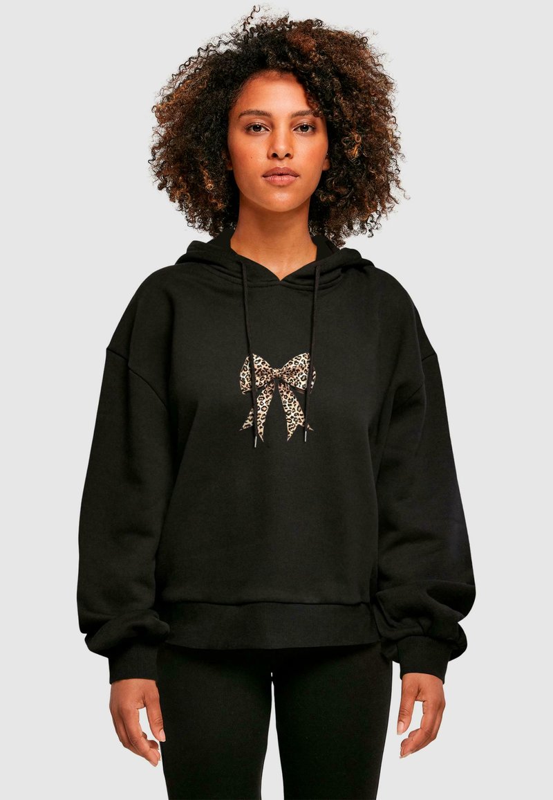 Felpa nera con cappuccio realizzata in un materiale morbido, con una grafica a forma di fiocco leopardato al centro. Vestibilità ampia con polsini e orlo a coste.