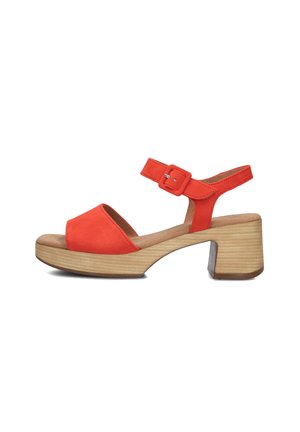 Orange suede heeled sandals with a wide open toe, adjustable ankle strap, and a chunky wooden block heel. Flat platform base.