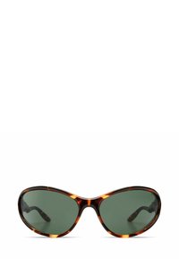 Lunettes de soleil écaille de tortue brune avec des verres vert foncé. Forme ovale et texture lisse, présentant des branches courbes pour un ajustement sécurisé.