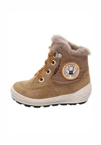Beige Wildlederschuh mit einem Pelzkragen, orangefarbenen Schnürsenkeln, silbernen Beschlägen und einem runden Aufnäher mit einem Hirschmotiv. Gummisohle mit strukturiertem Muster.
