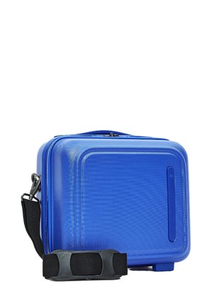 Sac de voyage rigide bleu avec une surface texturée, fermeture éclair et une sangle noire détachable. Design compact avec des coins arrondis.