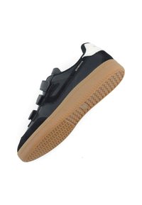 Black sneaker with a smooth upper, featuring two grey Velcro straps. Gum rubber outsole with a textured pattern. White accent on the heel.