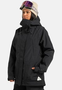 Schwarze wasserdichte Skijacke mit Kapuze, zwei Brusttaschen, verstellbaren Bündchen und einem Logo-Patch an der unteren Seite.