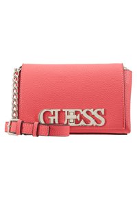 Borsa a tracolla in pelle martellata rosa con hardware in tono argento, caratterizzata da un evidente logo "GUESS" e una tracolla regolabile.