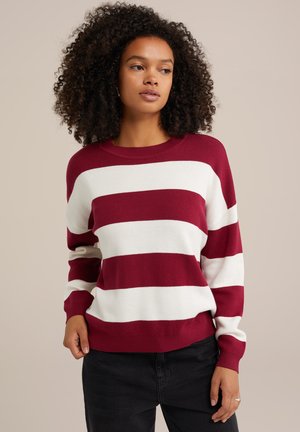 Gestreifter Pullover in Rot und Weiß mit rundem Halsausschnitt und langen Ärmeln, aus strukturiertem Strickstoff, kombiniert mit schwarzen Hosen.