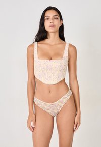 Floral lace bikini set in pastel yellow. Top features a square neckline and structured design; bottom has a scalloped trim.