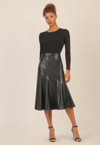 Schwarzer Lederrock mit ausgestellter Silhouette, hoher Taille und diagonalen Nahtdetails. Glatte Textur und minimalistisches Design.