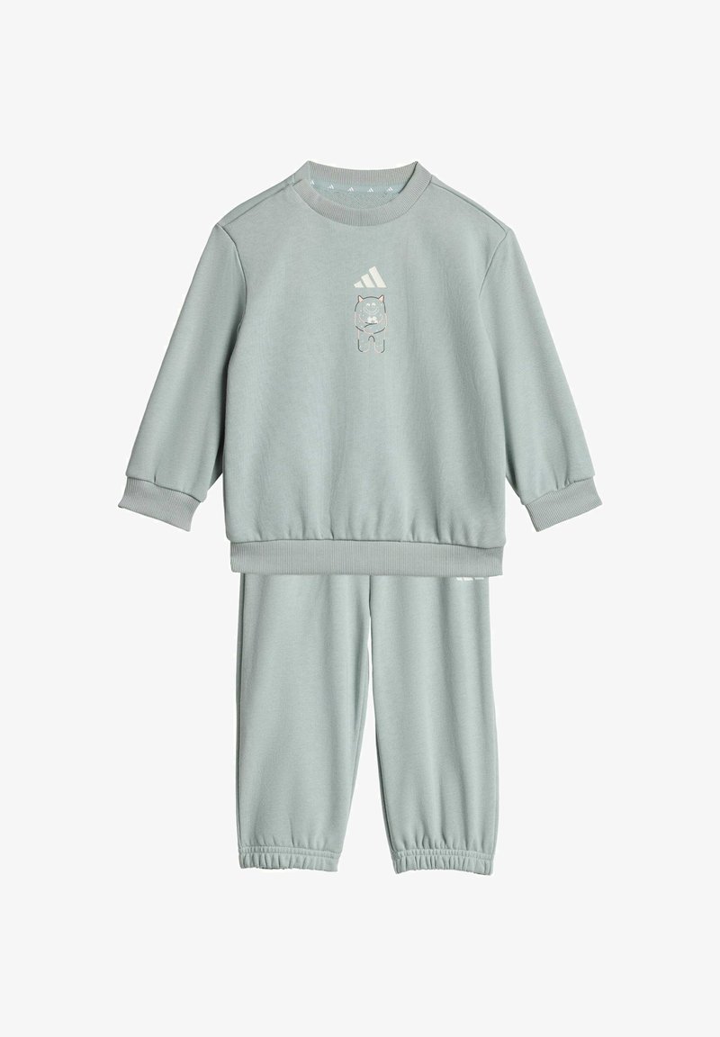 Svijetlozeleni pamučni trenirka koja se sastoji od dukserice s rebrastim manžetama i grafikom mede, uparenih s hlačama na elastiku.