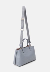 Bolso de mano texturizado de color azul claro con asas superiores y correa de hombro ajustable con marca, exhibido sobre un fondo blanco.