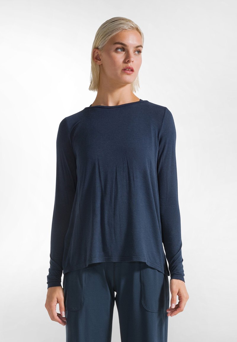 Maglietta a maniche lunghe blu navy in un tessuto liscio, con una vestibilità comoda, scollatura rotonda e delicate pieghe sui lati per maggiore comodità.