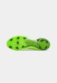 Semelle de chaussure de football verte avec une surface texturée, six pointes moulées pour la traction et un bord incurvé pour une agilité améliorée.