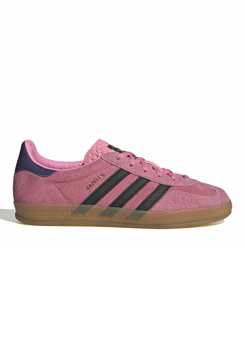 Nízkoprofilový sneaker Adidas Gazelle v růžové nubukové kůži s černými pruhy, gumovou podrážkou a fialovým patním štítkem, boční pohled.