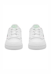 Adidași albi cu un tipar din piele netedă, vârf perforat și accente verzi ale logo-ului pe limbă și pe lateral. Design clasic cu șireturi.