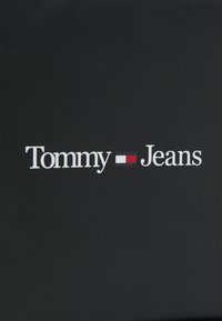 Black leather background with the white text "Tommy" and "Jeans," featuring a horizontal red and white emblem between the words.