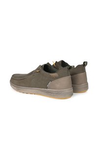 Chaussures en suede vert foncé avec une profile bas et une semelle en caoutchouc souple. Présentent des accents jaunes, des œillets et un logo subtil sur le côté.
