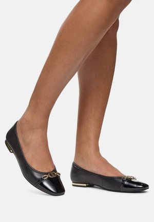 Bailarinas de cuero negro con punta afilada, parte delantera negra brillante, adornos decorativos en dorado y tacón bajo.