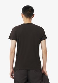 Kortærmet T-shirt med rund hals i mørkebrun, lavet af bomuld, med en glat tekstur og et enkelt, udekoreret design.
