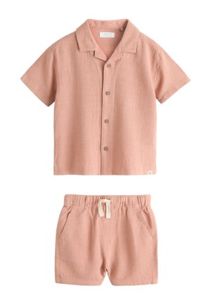 Koszula z krótkim rękawem w kolorze pudrowego różu na guziki oraz pasujące szorty z elastycznym pasem i białym sznurkiem, wykonane z teksturowanego materiału.