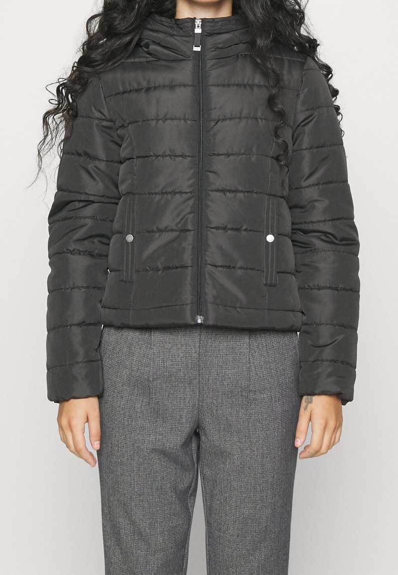 Svart puffjacka med dragkedja framtill, horisontella sömmar och hög krage. Har sidofickor och en slät, glänsande textur.