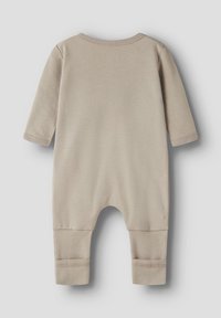Barboteuse pour bébé beige à manches longues, avec poignets repliés et encolure arrondie, présentée à plat sur un fond gris clair.