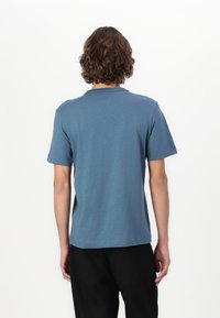 Tricou blue cu mânecă scurtă, realizat dintr-un material moale, cu guler rotund și tiv drept. Design minimalist, fără modele sau logo-uri vizibile.