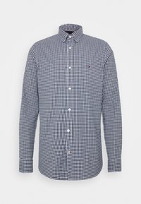 Camisa de manga larga a cuadros en navy y blanco con cuello abotonado y botones blancos; presenta un pequeño logo en el pecho.
