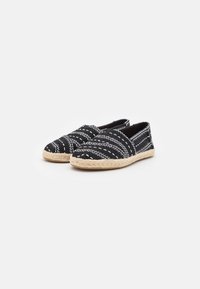 Espadrillas intrecciate in bianco e nero con superiore a motivo e suola in corda, dotate di design slip-on e punta arrotondata.