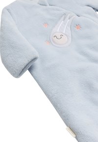 Mono de bebé de felpa azul suave con un cometa sonriente bordado y estrellas naranjas. Mangas con puños para mayor comodidad.