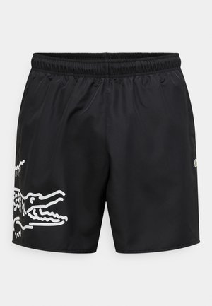 Shorts de bain noirs avec une ceinture élastique, comportant un graphisme de crocodile blanc sur le côté gauche et un accent logo sur le côté droit.
