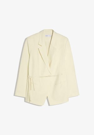 Cream-colored long-sleeve blazer with lapel collar, front pockets, and side tie detail, displayed on a white background.