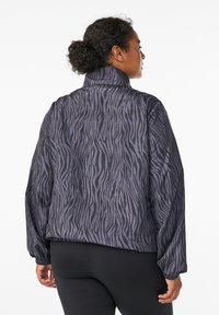 Dunkelpurpurne Pufferjacke mit Zebramuster. Verfügt über einen hohen Kragen und elastische Bündchen. Das Material wirkt glatt und leicht.
