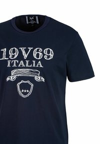 Navyblauwe katoenen T-shirt met een witte bedrukte ontwerp met "19V69 ITALIA," een schild en decoratieve accenten. Klassiek crew neck-stijl.