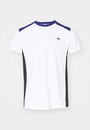 T-shirt atlético branco com detalhes roxos nos ombros e painéis laterais pretos. Apresenta um pequeno logotipo verde no peito. Feito de tecido respirável.