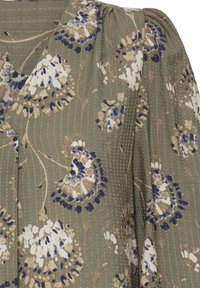 Õieprint kangas oliivrohelises värvitoonis valgete ja tumesiniste lilledega. Omab tekstuuriga triibusid ja kogutud varrukaid. Peen läikiva viimistlusega.