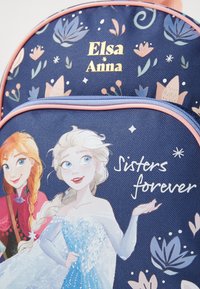 Mochila com personagens animados Elsa e Anna, padrões florais e texto "Elsa Anna" e "Irmãs para sempre" sobre um fundo azul escuro.