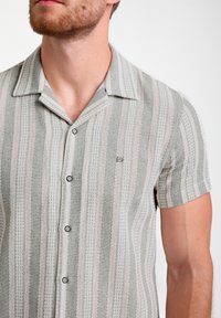 Gestreept shirt met korte mouwen in grijs en wit met subtiele roze accenten, uitgerust met een kraag en knoopsluiting aan de voorkant, van textuurstof.