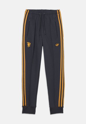 Marineblauwe sweatpants met oranje strepen, met ritszakken, geribbeld uiteinde, en geborduurd logo op de linkerdij en heup.