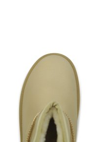 Beige waterdichte enkellaars met een gladde textuur, ronde neus en zachte binnenvoering; beschikt over een gestructureerde rubberen zool en zichtbare stiksels.