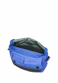 Blaue Umhängetasche mit offenem oberen Teil, der das schwarze Innenfutter und zwei Fronttaschen mit Druckknopfverschlüssen offenbart.