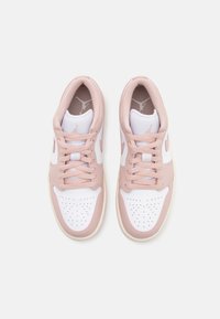 Světle růžové a bílé sportovní boty s perforovanou špičkou, šněrováním a viditelným logem na jazyku a stranách. Plochá gumová podrážka.