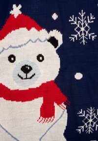 Maglione lavorato a maglia con un orso polare che indossa un cappello e una sciarpa rossa da Babbo Natale, su uno sfondo blu navy, impreziosito da fiocchi di neve e pois bianchi.