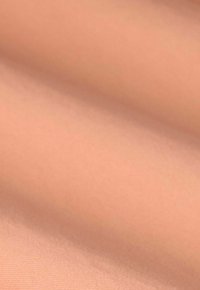 Tissu beige clair, texture lisse, avec un éclat subtil. Se drape en douceur, présentant un motif de tissage fin et régulier.