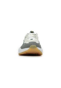 Zapatillas deportivas con una parte superior de malla blanca, acentos de ante gris, suela de goma y detalles en verde, con una punta texturizada y cordones.