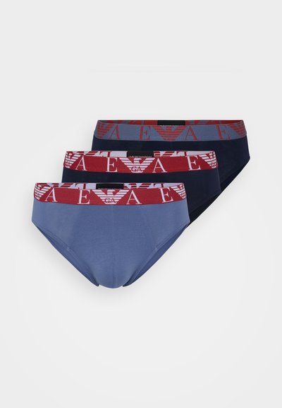 Trois paires de slips en bleu, marine et bordeaux. Chacun présente une ceinture logo avec des motifs répétitifs. Matière douce en coton, coupe standard.