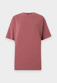 T-shirt uni mauve à manches courtes et col rond, présenté sur fond blanc, sans logo ni motif visible.