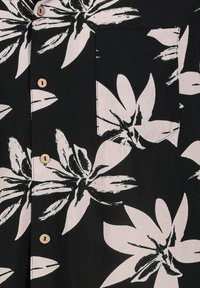 Schwarzes Button-Up-Hemd mit großen weißen Blumenmustern. Auffällige Details sind Holzknebel und eine Brusttasche.