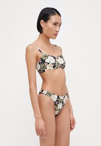 Blommig bikiniuppsättning med svart bas, prydd med ljusblå och rosa blommor. Justerbara tunna axelband, sömlös design och lågt skuren botten.